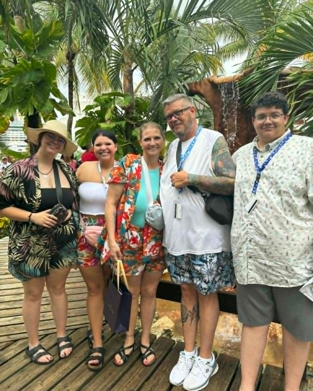 Group of people posing for a photo in a tropical setting with palm trees.